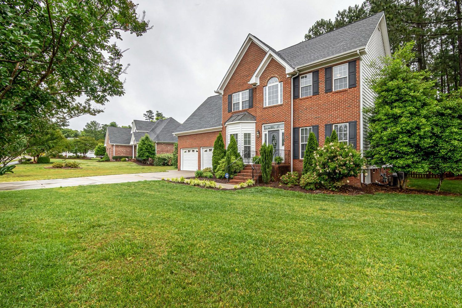 Brick two-story home with a manicured lawn
